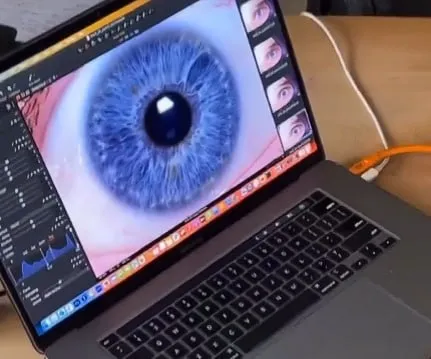 Laptop screen displaying a high-resolution blue iris photo